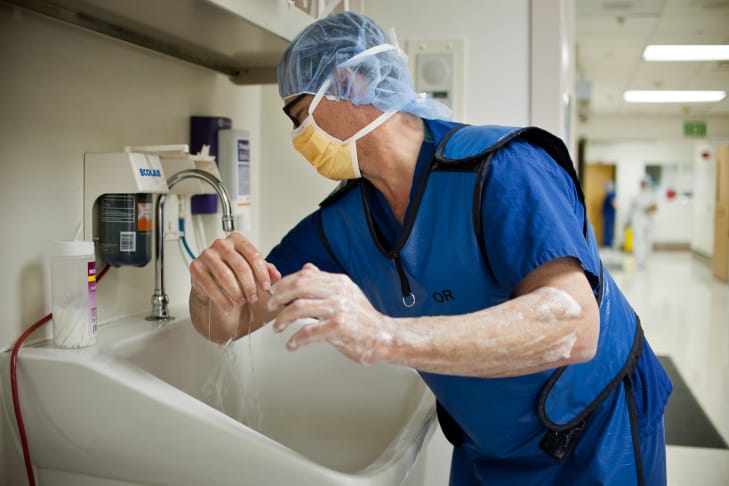 A surgeon scrubs his hands and arms before going into the operating room at Riverside County Regional Medical Center.
