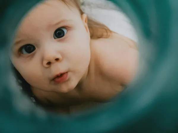 Baby peering through a tube