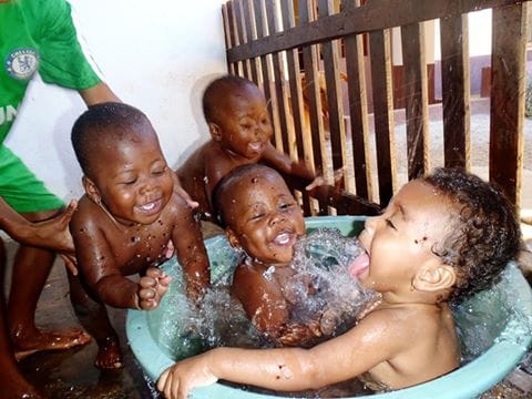 Triplets Hakima, Alima and Rahima enjoy bathtime with their friend Melanie at the Arnaud Guesry Foundation children's home, M