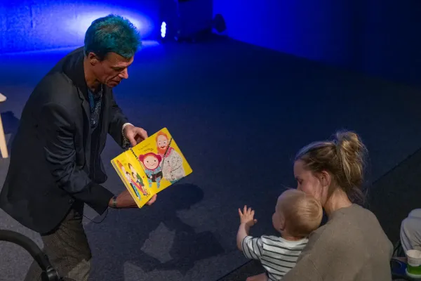 Caspar showing his book Babies Laugh at Everything to a baby during the show